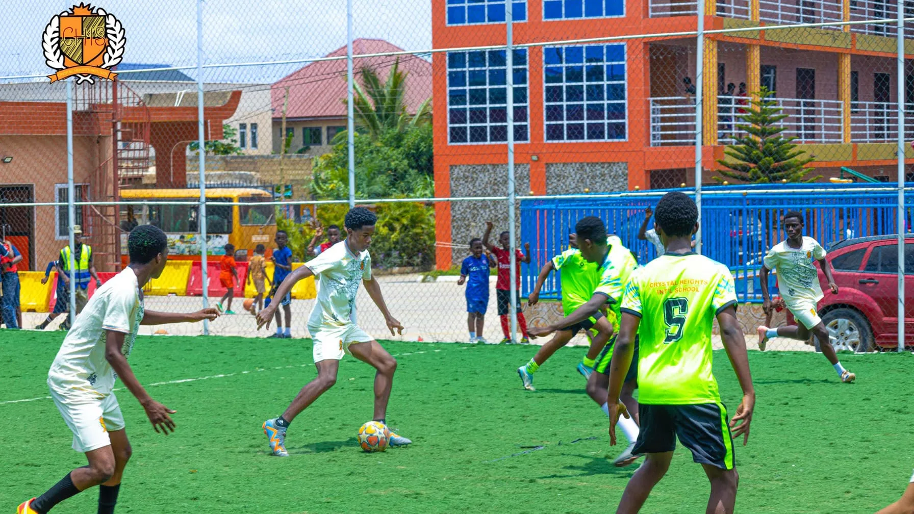 A football match on the school astroturf, buildings behind