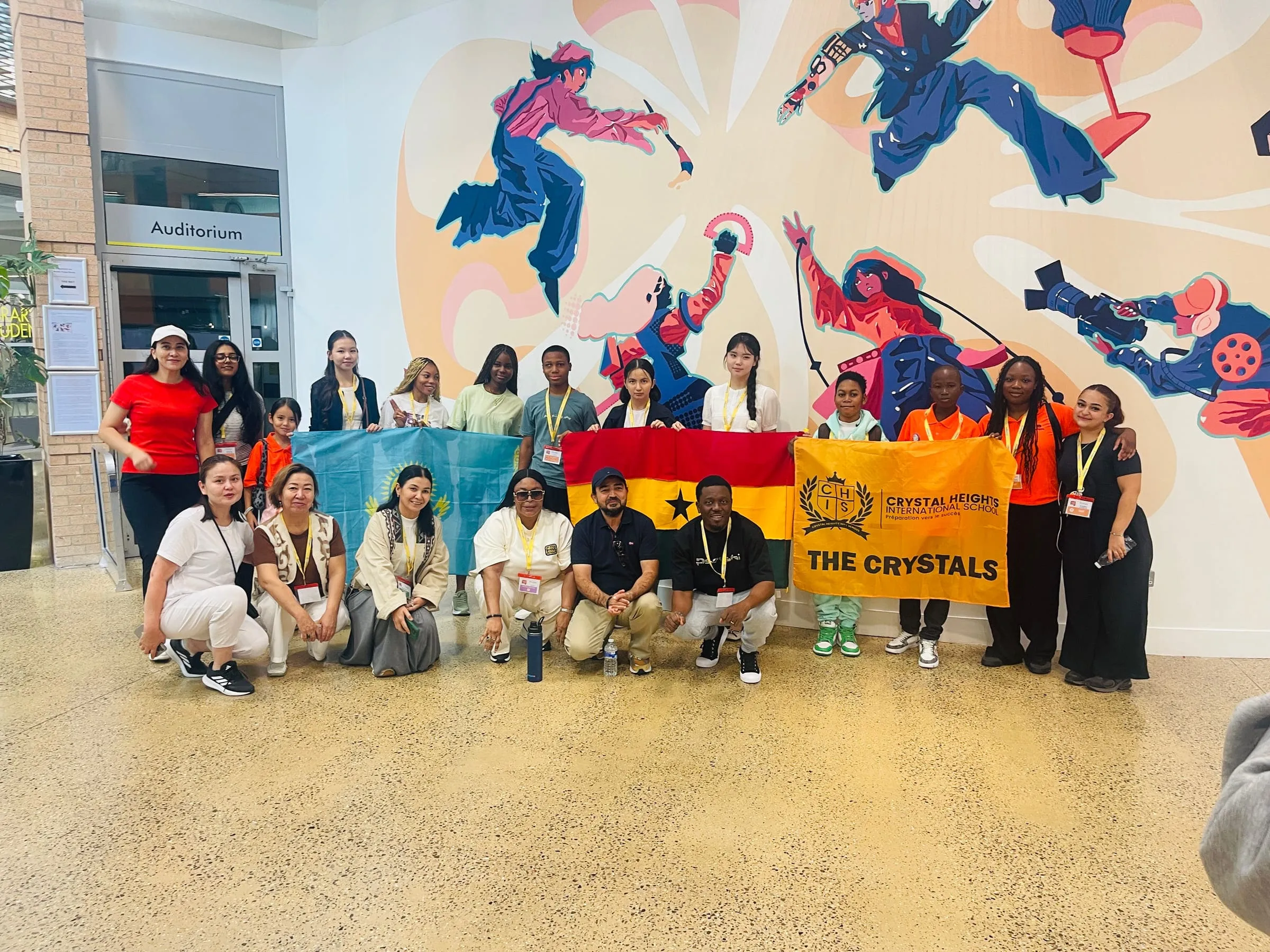 The Crystal Heights delegation with their team banner and the Ghanaian flag at Owlypia Global