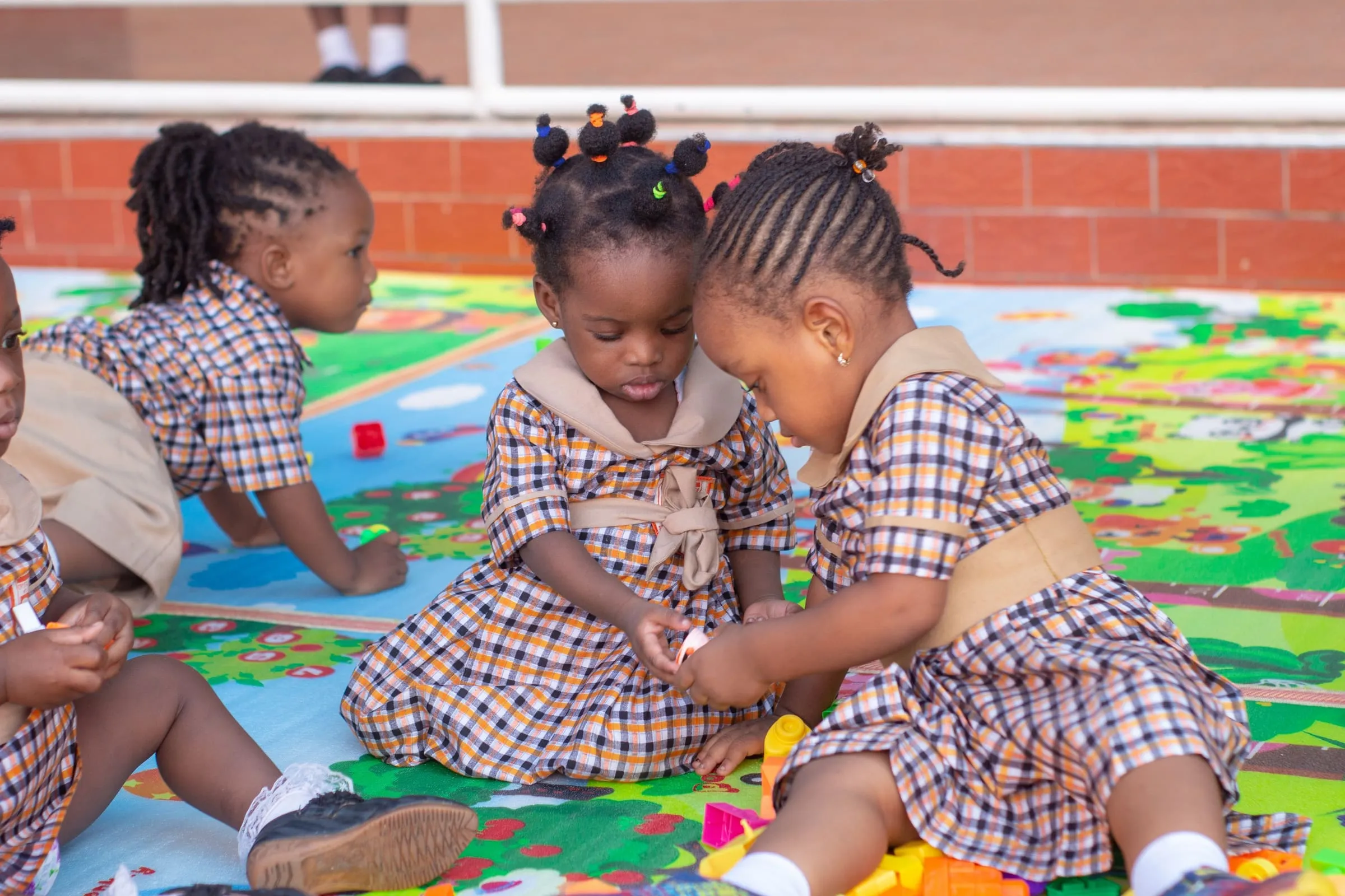 Crystal Heights preschool children playing with building blocks on the classroom floor mat