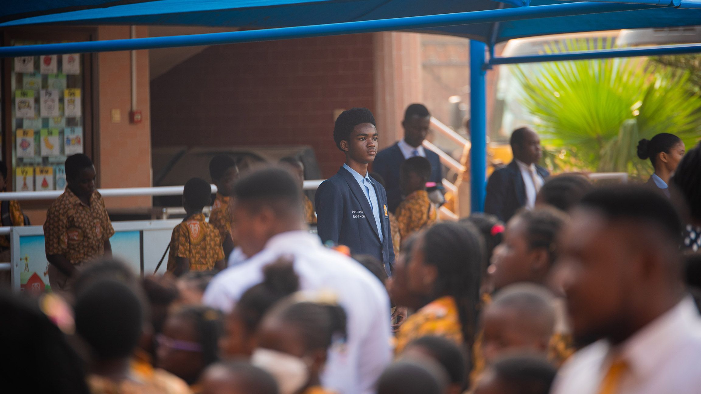Morning assembly at Crystal Heights, a student in the Pearson Edexcel blazer among the crowd