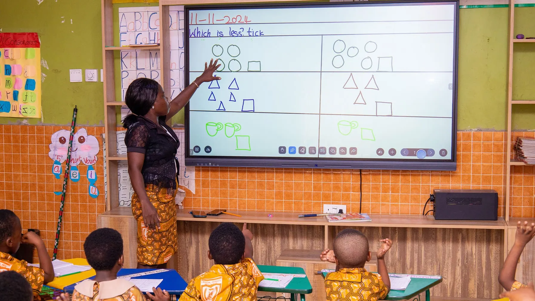 A teacher at the interactive smart screen with a preschool class